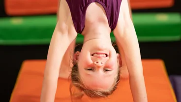 A gymnast upside down in a handstand during Beginning Tumbling at Cal Elite