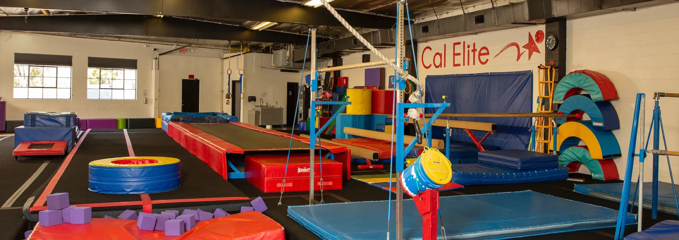 Inside Cal Elite Burbank, with gymnastics equipment and padded floors